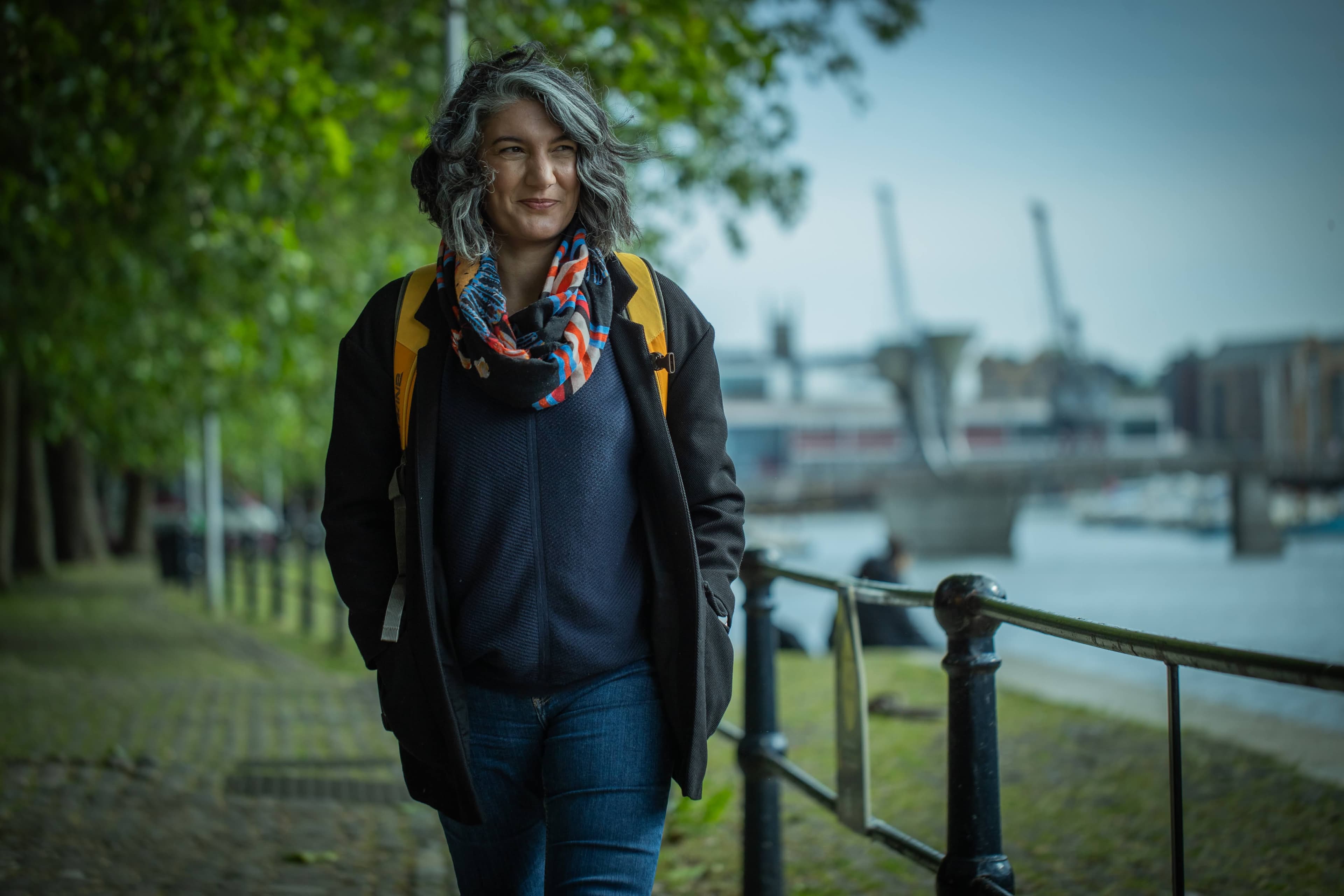Karen Velasquez walking along a riverside path in London